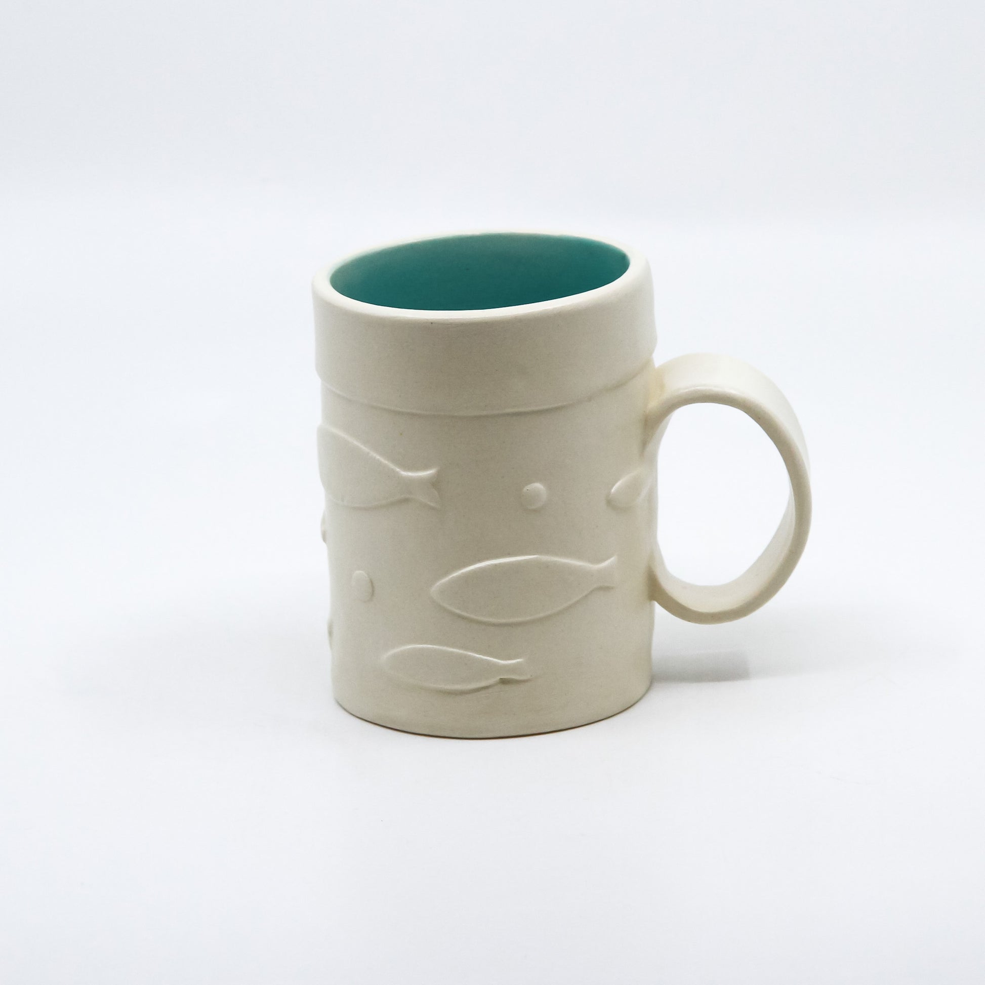 White mug with fish and turquoise inside