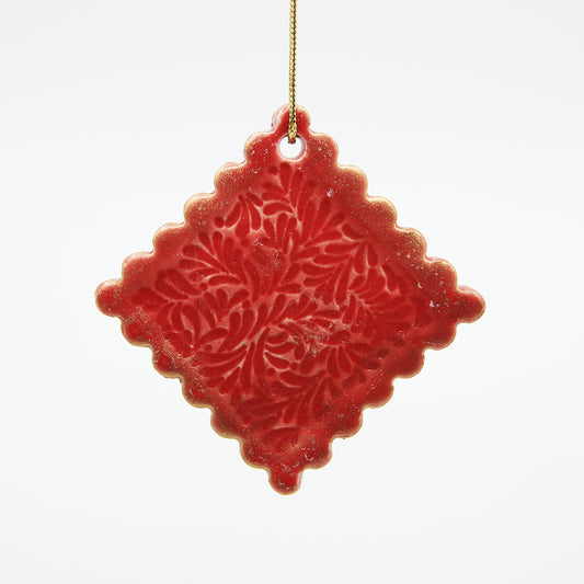 Red diamond clay Christmas ornament with carved pattern and scalloped edges, dusted with gold luster 