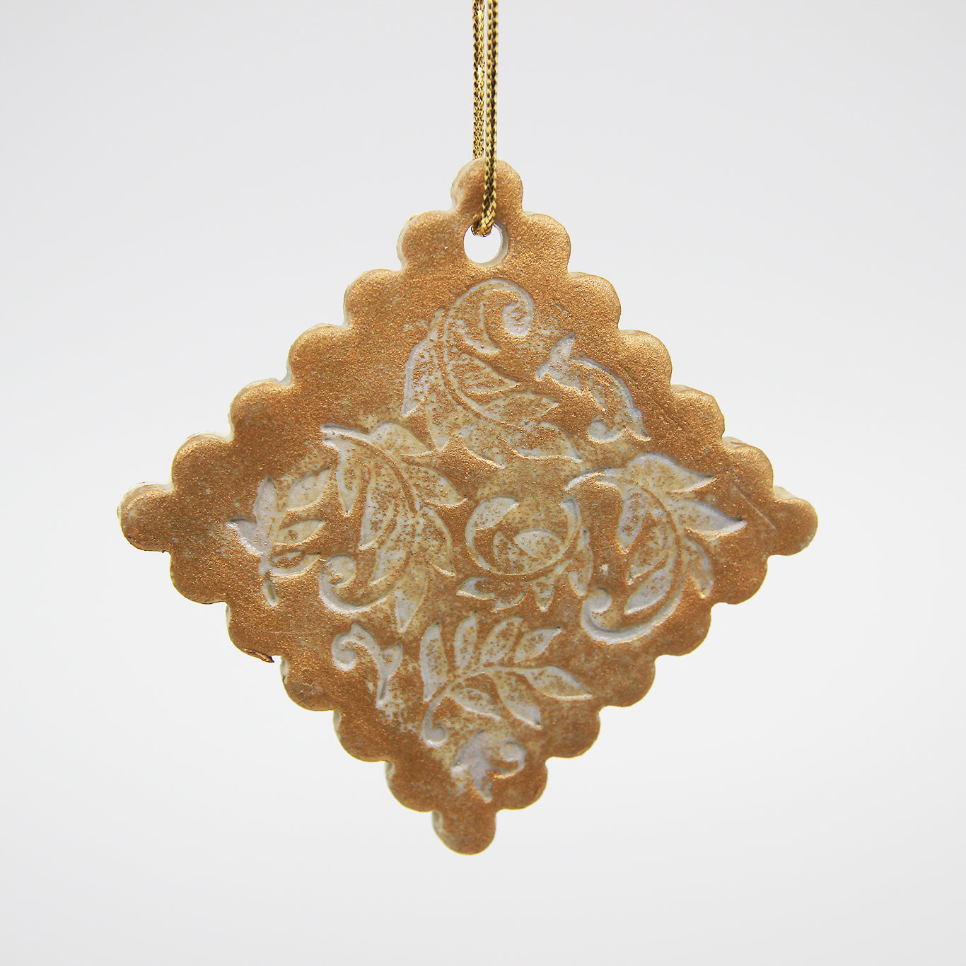 Golden diamond Christmas ornament with carved leaves and scalloped edges