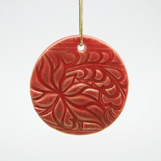 Red circle clay ornament dusted with gold luster and carved pattern