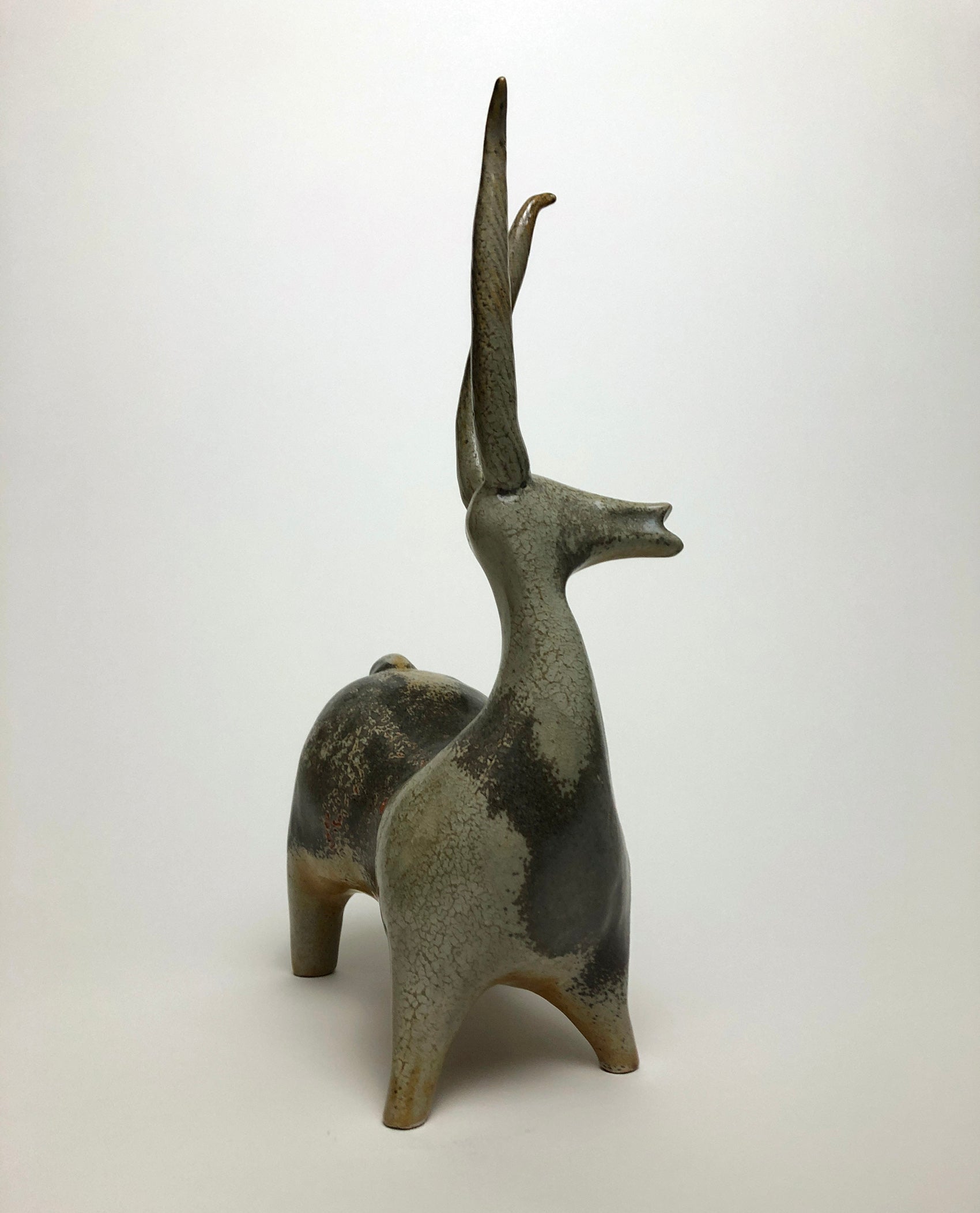 Clay sculpture of a brown stag with long horns 